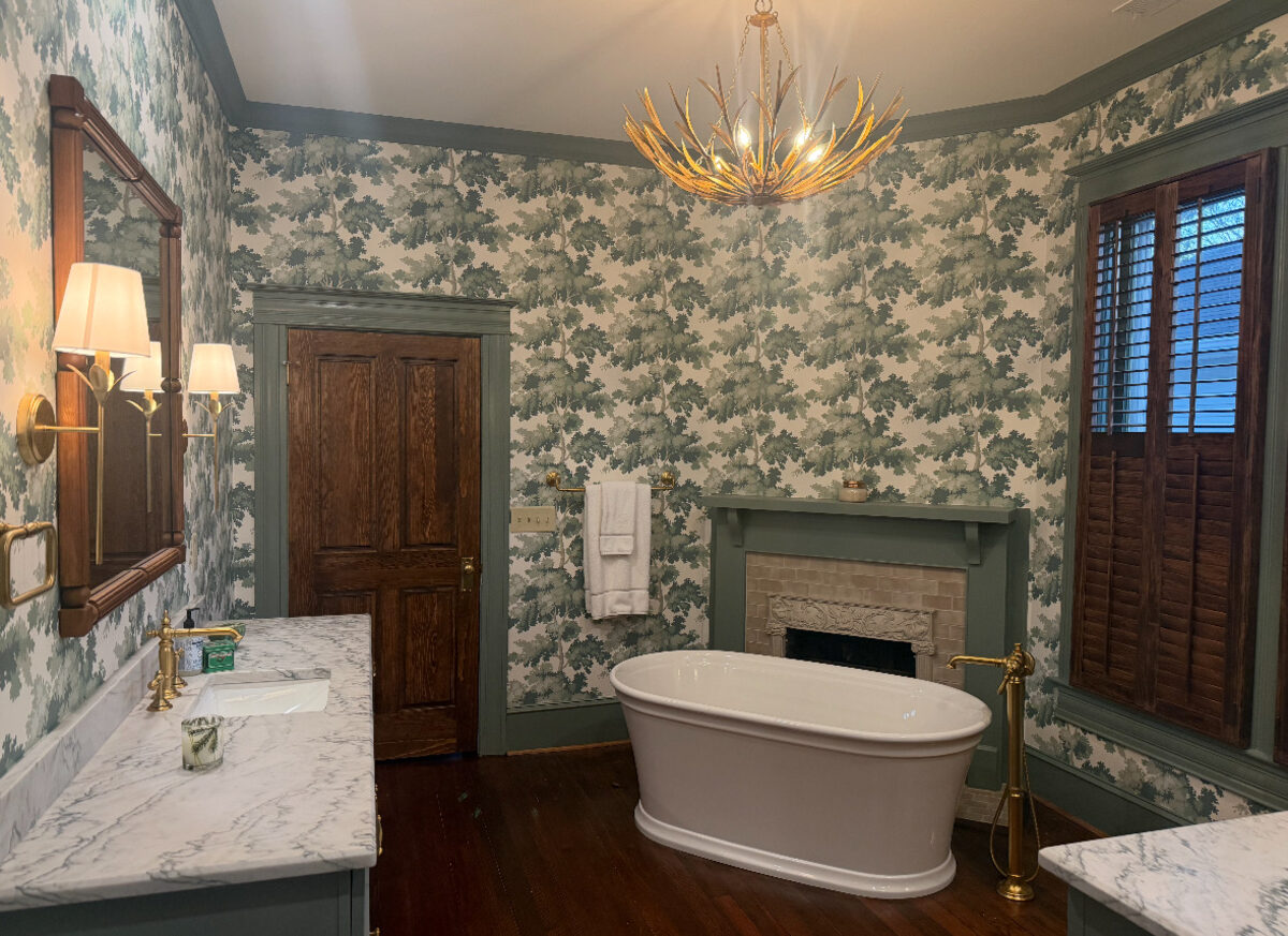 Elegant master bath with botanical wallpaper and freestanding tub by MW Designs